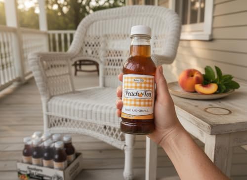 A hand holding a Southern Sweet Tea Co. Peach Iced Tea bottle on a porch with a 12-pack and fresh peaches.