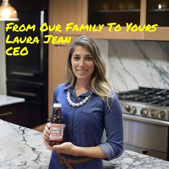 CEO Laura Jean holding Southern Sweet Strawberry Black Tea in a kitchen with marble countertops.